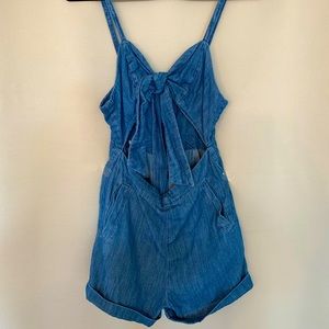 Denim romper with adjustable straps and tied bow in front